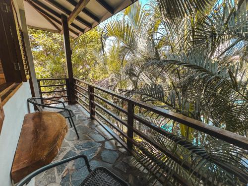 a balcony with a table and chairs and palm trees at Villa Eden Palomino in Palomino
