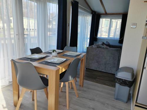 a dining room table and chairs in a room with windows at Dog Friendly 8 Berth Lodge, 600 Yard's From The Beach In Hunstanton in Hunstanton