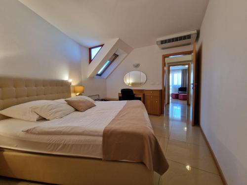 a bedroom with a bed and a desk and a window at Aparthotel Gaja in Bled