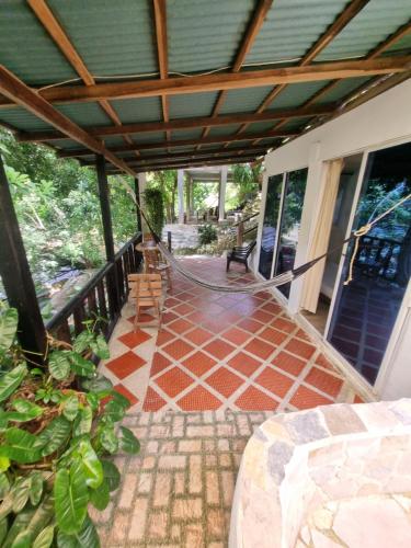 a porch with a hammock on a house at Kankui Lodge in El Zaino