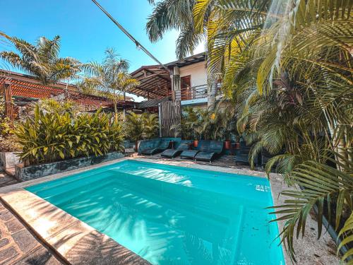 a swimming pool in front of a house with palm trees at Villa Eden Palomino in Palomino