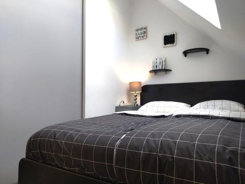 een slaapkamer met een zwart bed met witte kussens bij Apartment Lila in Zagreb