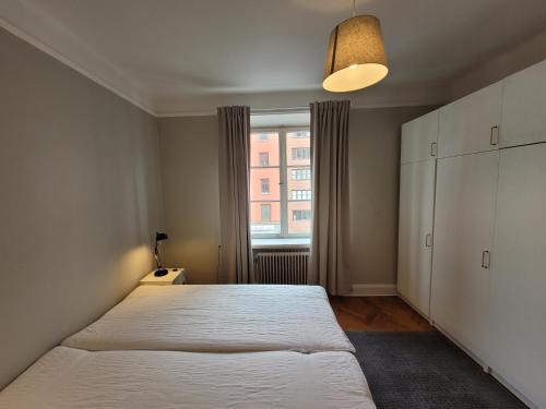 Home Inn FKG110 في ستوكهولم: غرفة نوم بسرير كبير ونافذة