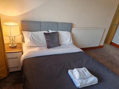 a bedroom with a large bed with two towels on it at Heads on Bed Pitsea Basildon Essex House with Free Parking Netflix & Wifi in Basildon