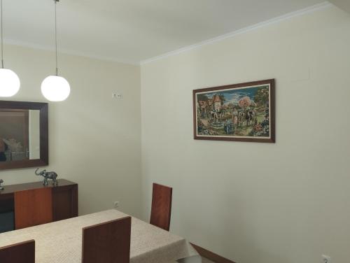 a dining room with a picture on the wall at Casa da Ribeira in Senhora do Rosário