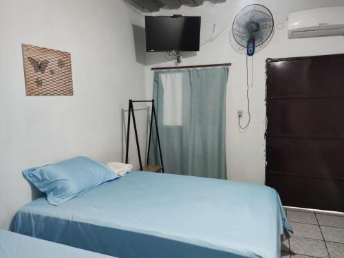Hostal Santa Marta في لا يونون: غرفة نوم بسرير ومروحة