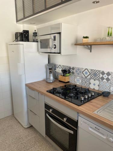 a kitchen with a stove and a refrigerator at Vue magnifique in Vernet-les-Bains