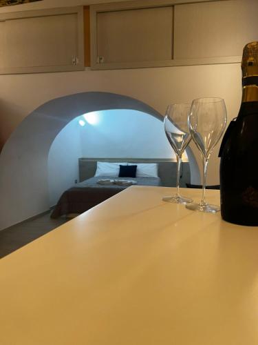 two wine glasses sitting on a table with a wine bottle at Vicolo Garibaldi in Tropea