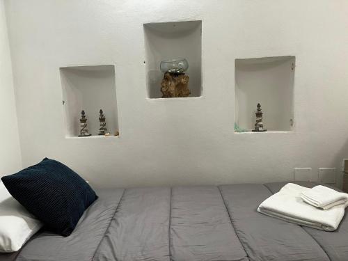 a bedroom with a bed with two windows and a bowl on the wall at Vicolo Garibaldi in Tropea