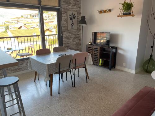 a dining room with a table and chairs and a television at Vue magnifique in Vernet-les-Bains