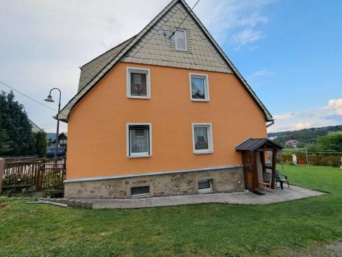 a large orange house with a gambrel roof at Ferienwohnung Böhmischerblick in Bärenstein