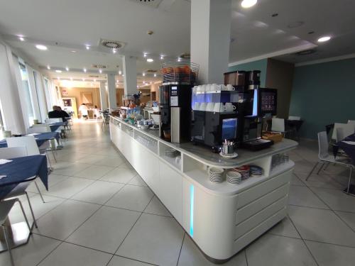 a coffee shop with a long counter with aresso at Hotel Oceanomare in Punta Marina