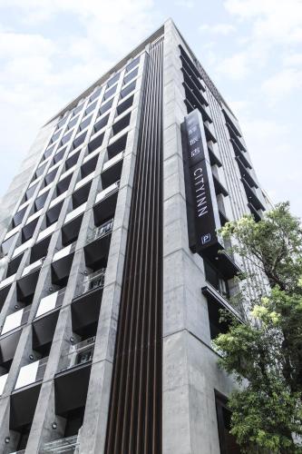 a tall building with a sign on the side of it at CityInn Hotel Plus- Fuxing North Road Branch in Taipei