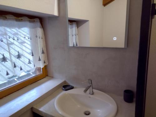 a bathroom with a sink and a window at Chalet La Ferme d'Henriette, à Samoëns in Samoëns