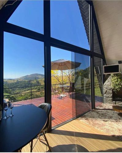 a view of a patio with a table and an umbrella at Cabana Raízes: A-Frame com vista para as montanhas in Baependi