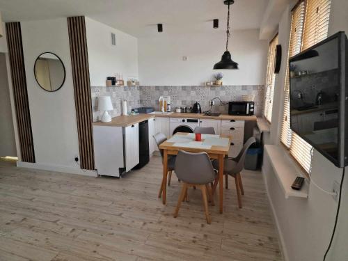 Apartament Gryfice في غريفيتسه: مطبخ مع طاولة وكراسي في غرفة