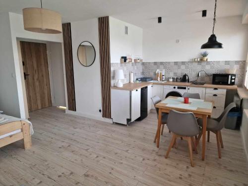 Apartament Gryfice في غريفيتسه: مطبخ مع طاولة وكراسي في غرفة
