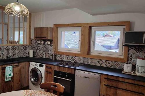 a kitchen with a washer and dryer and two windows at ski chamonix, Saint Gervais et mont-blanc in Passy