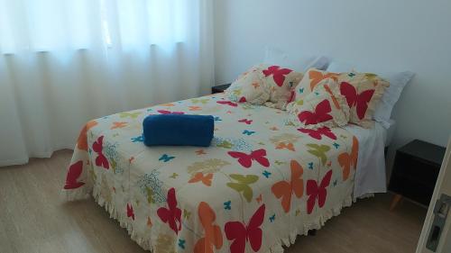 a bed with a comforter with butterflies on it at Casa no centro de Petrópolis in Petrópolis