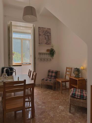 a living room with a table and chairs and a window at Dolce Farinella in Putignano