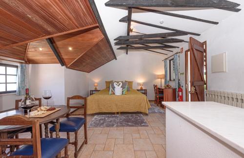 a room with a bed and a table with chairs at Quinta de São Pedro in Sobreda