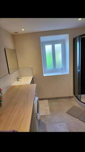 une cuisine avec un comptoir, un évier et une fenêtre dans l'établissement Maison accueillante avec cour et parking privé, à Châtillon-sur-Cher