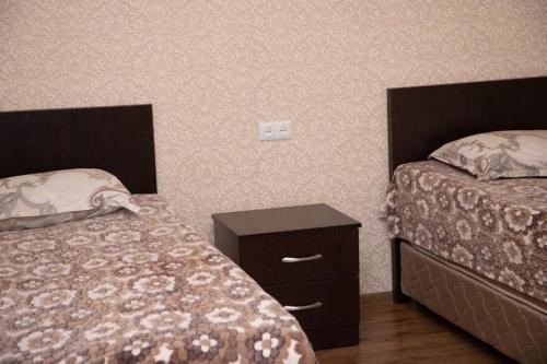 a bedroom with two beds and a nightstand with two beds at Sevan Hotel in Sevan