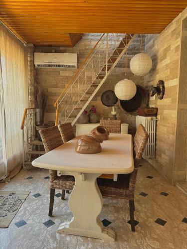 a dining room with a table with chairs and a staircase at Dolce Farinella in Putignano