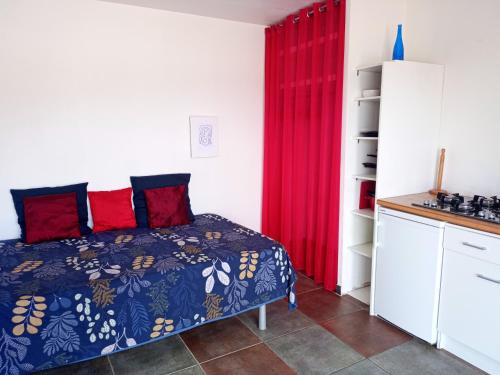 a bedroom with a bed and a red curtain at Studio cosy in Nîmes