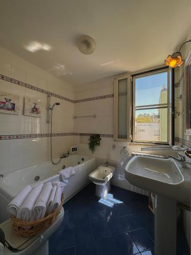 a bathroom with a tub and a toilet and a sink at Dolce Farinella in Putignano