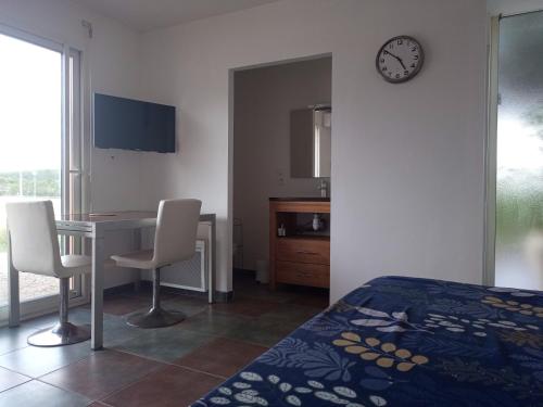 - une chambre avec un lit, un bureau et une horloge dans l'établissement Studio cosy, à Nîmes