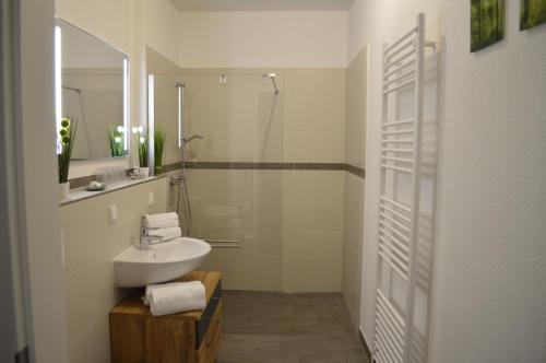 a white bathroom with a sink and a shower at Ferienwohnung MeerZeitPerle in Glowe