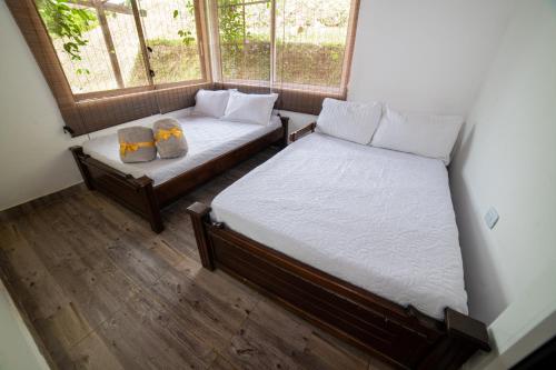 1 dormitorio con 2 camas y ventana en HOME SUITE, en Tuluá