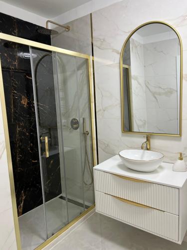 a bathroom with a shower with a sink and a mirror at LuxApart Apartamenty Jantar in Jantar