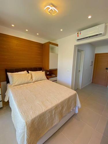 ein Schlafzimmer mit einem großen Bett und einer Klimaanlage in der Unterkunft Amerigo Loft Jardim - Morro de Sao Paulo Lofts in Cayru