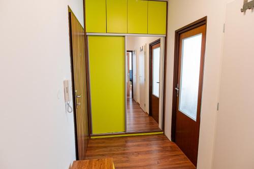 a hallway with green and yellow walls and wooden floors at Room 1 km from center in Bratislava