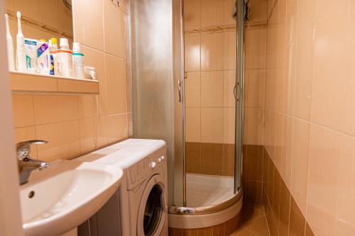 a bathroom with a shower and a washing machine at Room 1 km from center in Bratislava