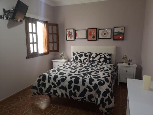 een slaapkamer met een zwart-wit bed en een raam bij La casa de Rei in Sardina