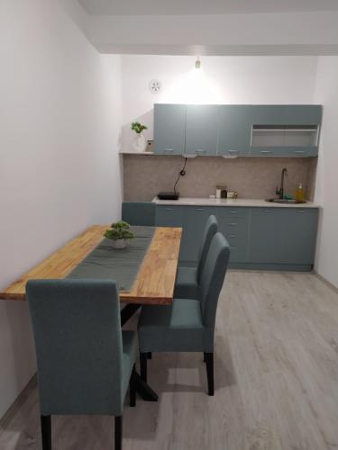 uma cozinha com uma mesa de madeira e cadeiras num quarto em Zamak em Niš