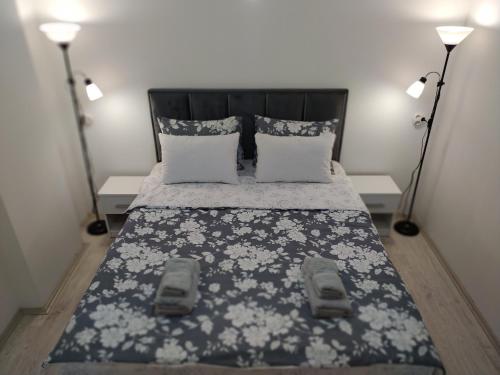 um quarto com uma cama preta e branca com 2 candeeiros em Zamak em Niš