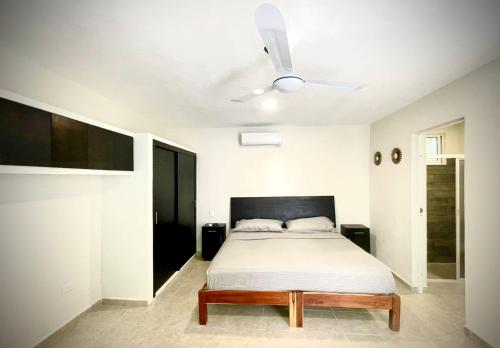 1 dormitorio con 1 cama y ventilador de techo en Casa Creunza de Mar, en Playa del Carmen