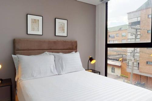 a bedroom with a bed and a large window at Apartamento 2 habitaciones Unicentro Scape in Bogotá