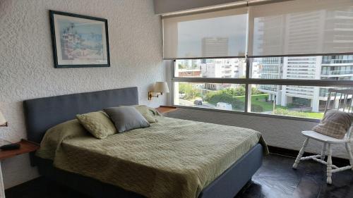 una camera con un letto e una grande finestra di Apartamento en Torre Del Plata II a Punta del Este