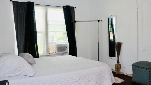 a bedroom with a white bed and a window at Be a part of Kingsville history in Kingsville