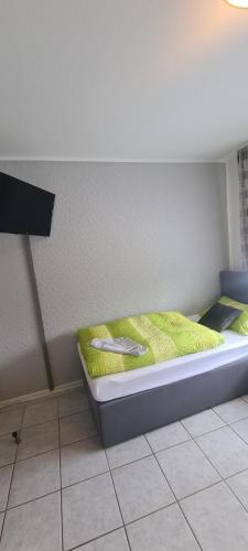 a bedroom with a bed with a yellow blanket at Hotel Zur Aue in Wesel