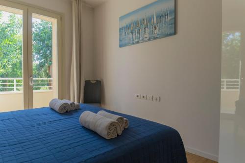 Un dormitorio con una cama azul con toallas. en Vacanzainmaremma - Ingresso indipendente 5 minuti dal centro - self check-in - free parking - wi-fi en Grosseto