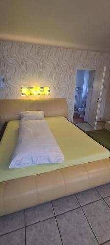 a large yellow bed with lights on it in a room at Hotel Zur Aue in Wesel