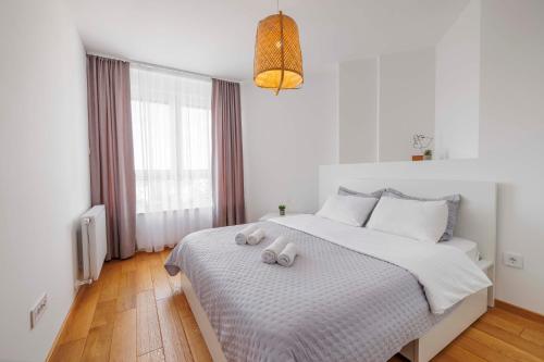 Un dormitorio con una cama con dos animales de peluche encima. en Panta Rhei Luxury Apartments, en Novi Sad