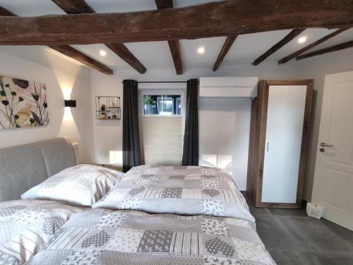 a bedroom with a bed with a white comforter at FeWo Antweiler Unterburg in Mechernich