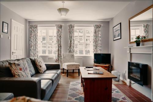 a living room with a couch and a tv at Courtyard Cottages at Ballyscullion Park in Derry Londonderry